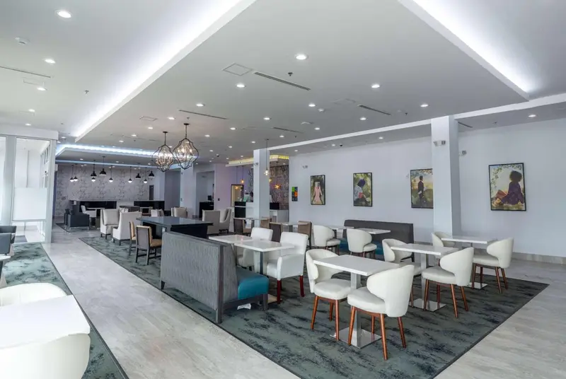 Une salle lumineuse avec des tables et des chaises pour les repas.