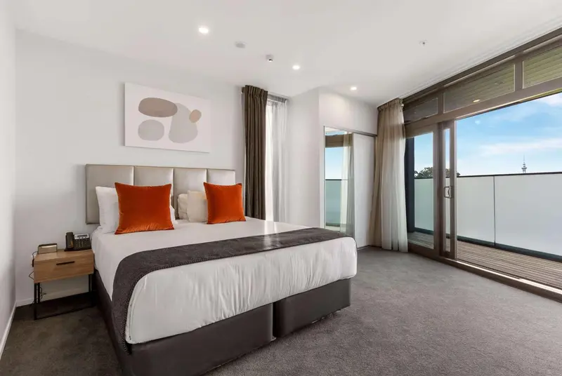 Une chambre moderne avec un grand lit et un accès à un balcon.