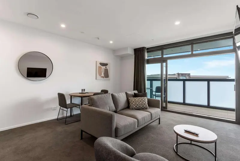 Un salon lumineux s'ouvre sur un balcon avec vue sur l'océan.