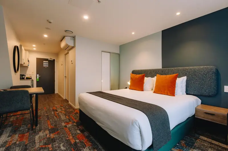 Chambre moderne avec un lit double et un coin repas.