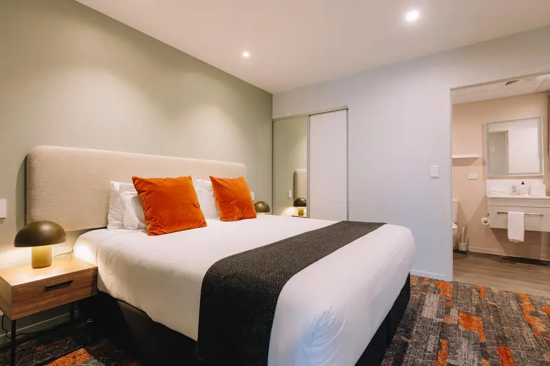 Une chambre d'hôtel moderne avec un grand lit et une salle de bain attenante.