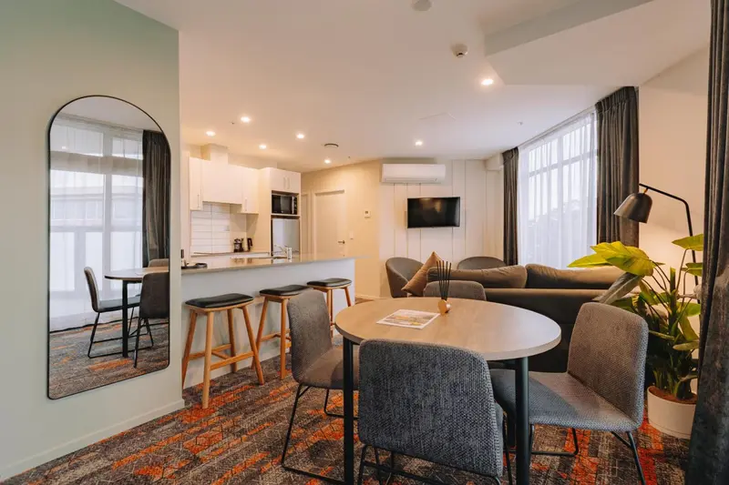 Espace de vie lumineux avec coin repas et cuisine ouverte.
