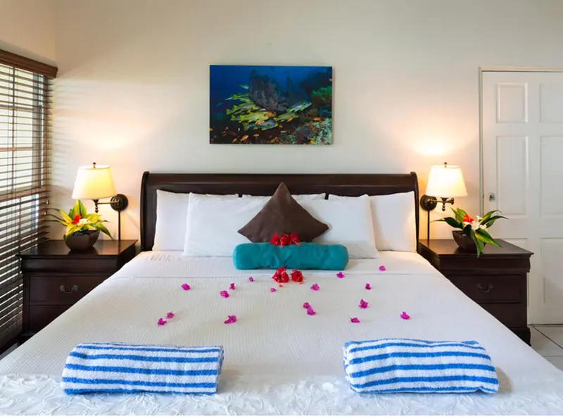 Une chambre avec un grand lit décoré de fleurs et de serviettes.