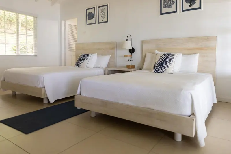 Deux lits simples dans une chambre lumineuse et minimaliste.