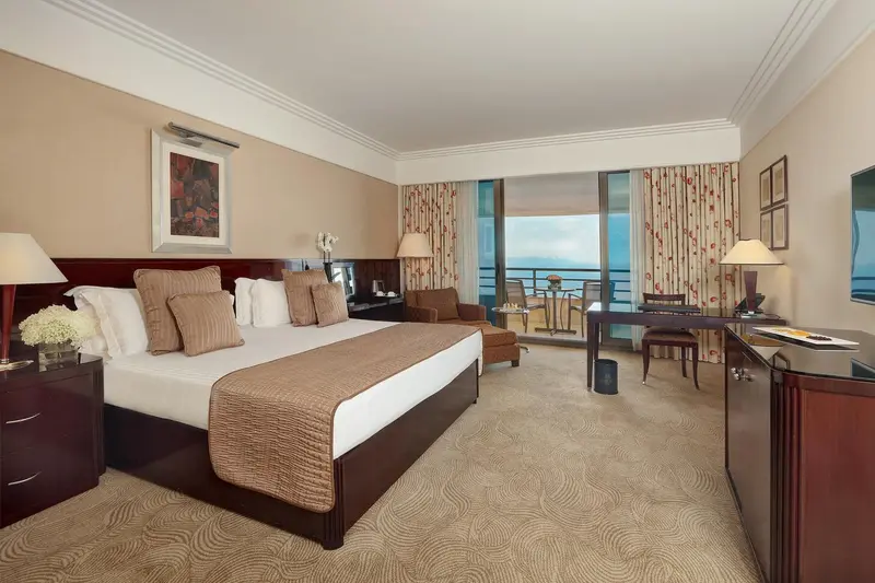 Une chambre d'hôtel spacieuse avec un grand lit et une vue sur la mer.