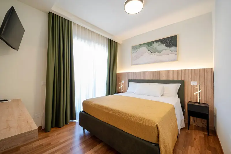 Une chambre lumineuse avec un grand lit et une décoration sobre.