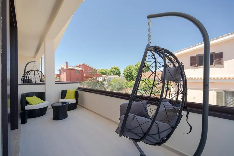 Terrasse aménagée avec des fauteuils suspendus et une vue sur les environs.