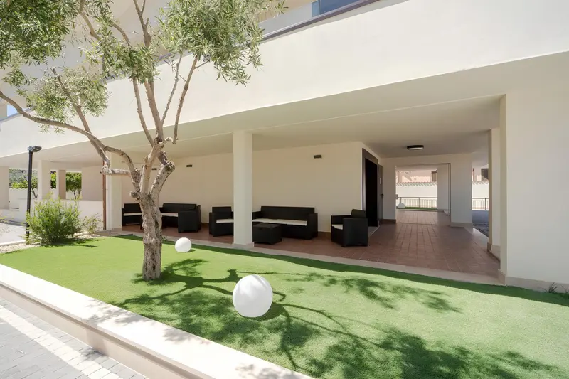 Espace extérieur aménagé avec des canapés et une pelouse artificielle.