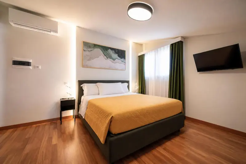 Une chambre lumineuse avec un grand lit recouvert d'une couverture jaune.