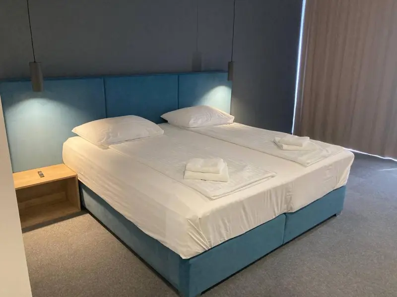 Une chambre lumineuse avec un grand lit recouvert d'une literie blanche.