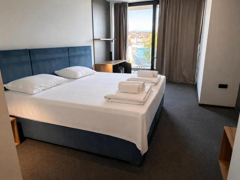 Une chambre lumineuse avec un grand lit et une vue sur la mer.