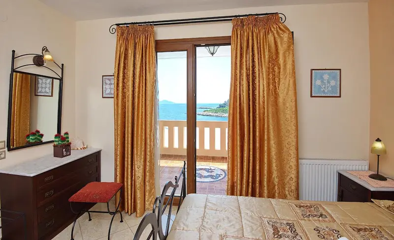 Une chambre lumineuse avec un bureau et un accès à une terrasse.
