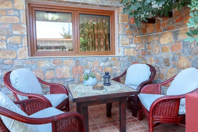 Espace extérieur aménagé avec table et chaises en rotin.