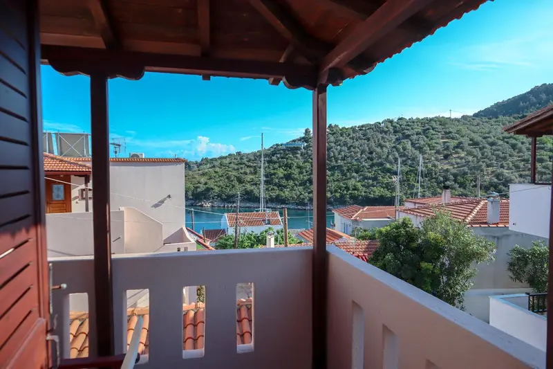 Vue sur un paysage côtier depuis un balcon ombragé.