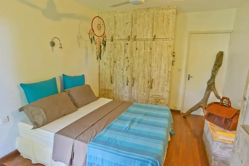 Une chambre lumineuse avec un grand lit et une décoration murale originale.