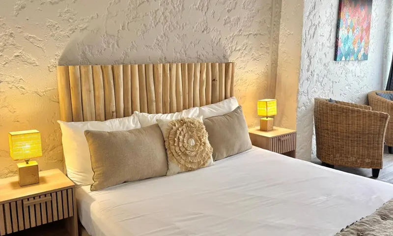 Une chambre lumineuse avec un grand lit et des tables de chevet.