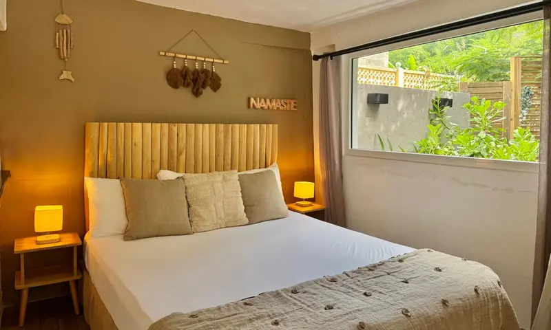 Une chambre lumineuse avec un grand lit et une décoration naturelle.