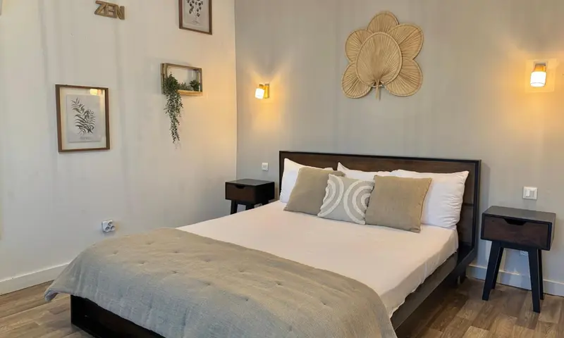 Une chambre lumineuse avec un grand lit et des décorations murales.