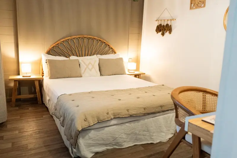 Une chambre lumineuse avec un grand lit et une décoration naturelle.