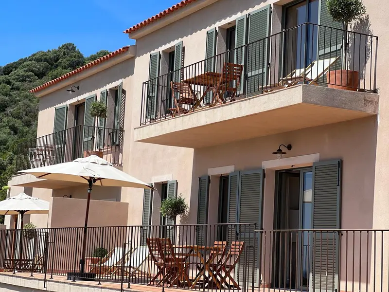 Façade d'un bâtiment avec des balcons et des parasols.