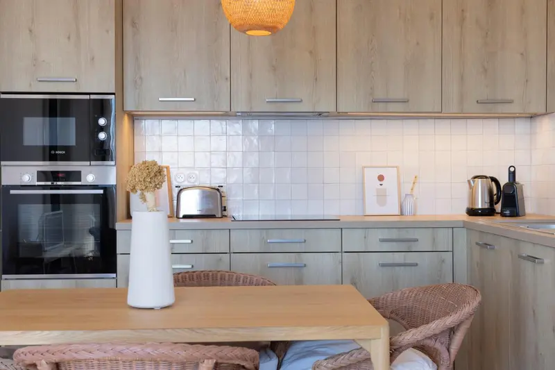 Une cuisine moderne avec des appareils électroménagers intégrés et un plan de travail en bois.
