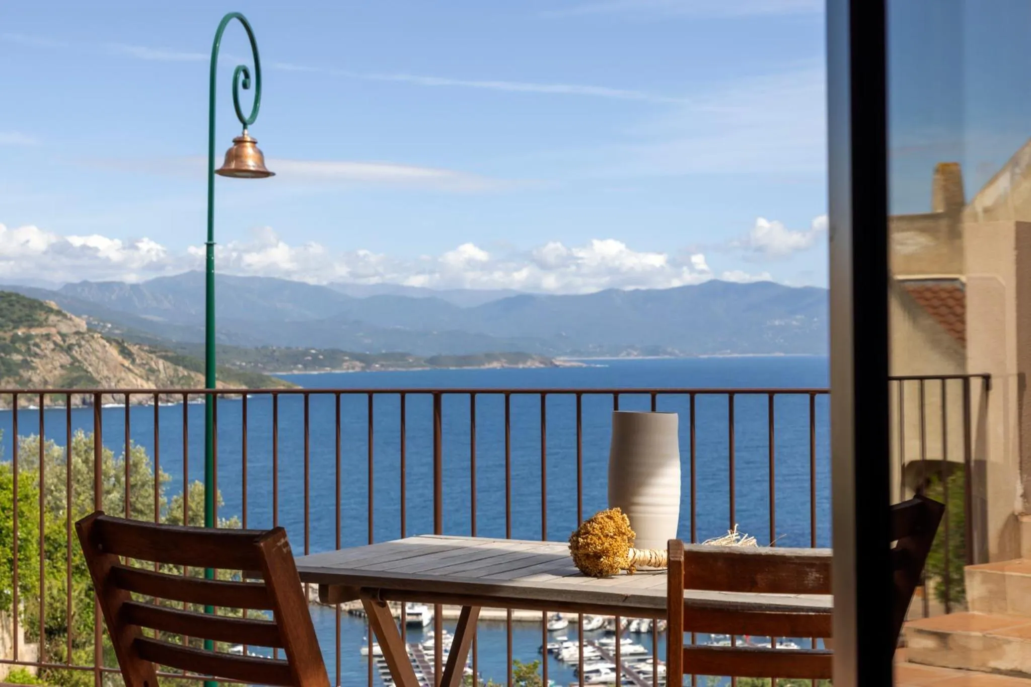 Vue sur la mer et les montagnes depuis une terrasse.