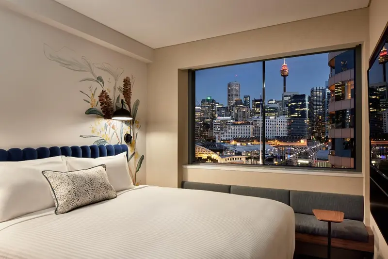 Une chambre d'hôtel lumineuse avec un grand lit et une vue sur la ville.