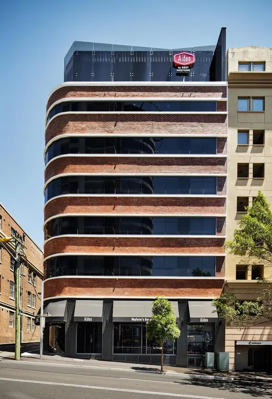 Façade d'un bâtiment moderne à plusieurs étages avec des fenêtres en arc.