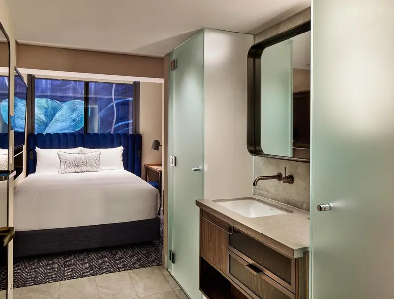 Une chambre moderne avec un lit et un coin lavabo.
