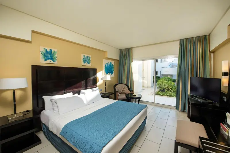 Une chambre lumineuse avec un grand lit et un accès à une terrasse.