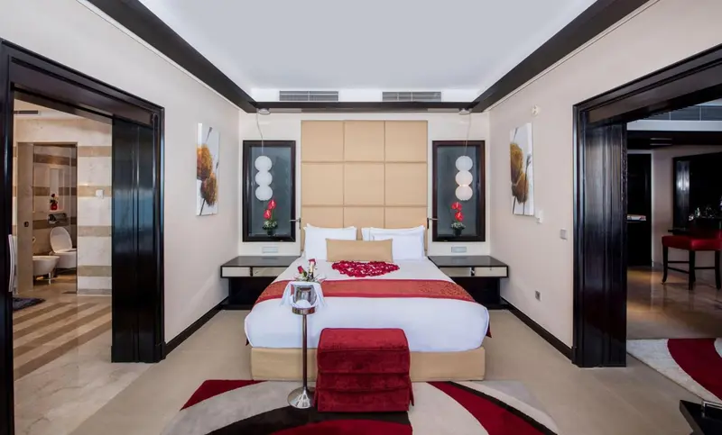 Une chambre moderne avec un grand lit et une décoration sobre.