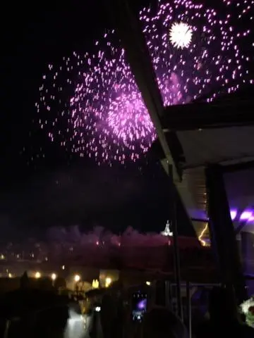 Feux d'artifice illuminant le ciel nocturne au-dessus d'une terrasse.