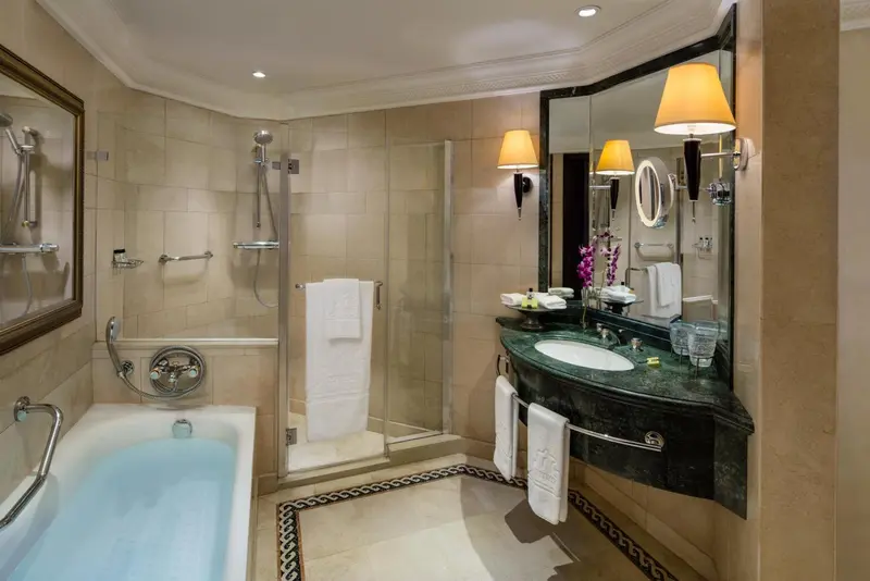 Une salle de bain lumineuse avec baignoire et douche à l'italienne.