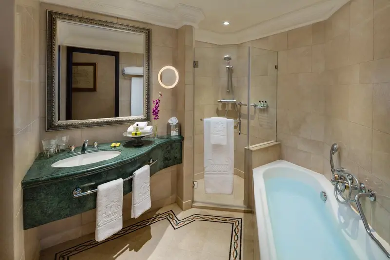 Une salle de bain lumineuse avec une baignoire et un grand miroir.