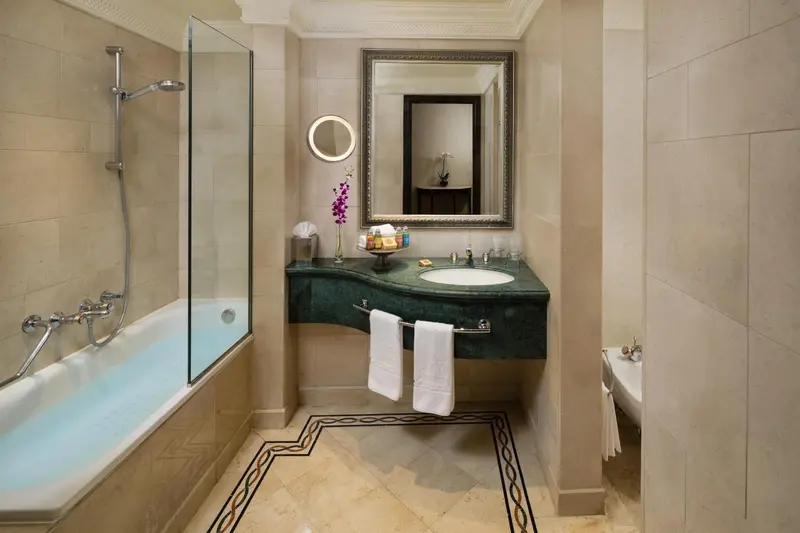 Une salle de bain lumineuse avec baignoire et lavabo en marbre.