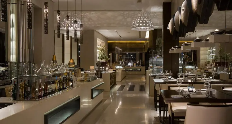 Une salle lumineuse avec un comptoir de buffet et des tables dressées pour le repas.