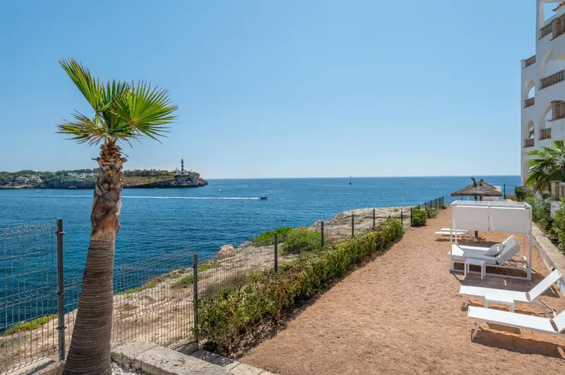 Terrasse avec transats et vue sur la mer et la côte rocheuse.