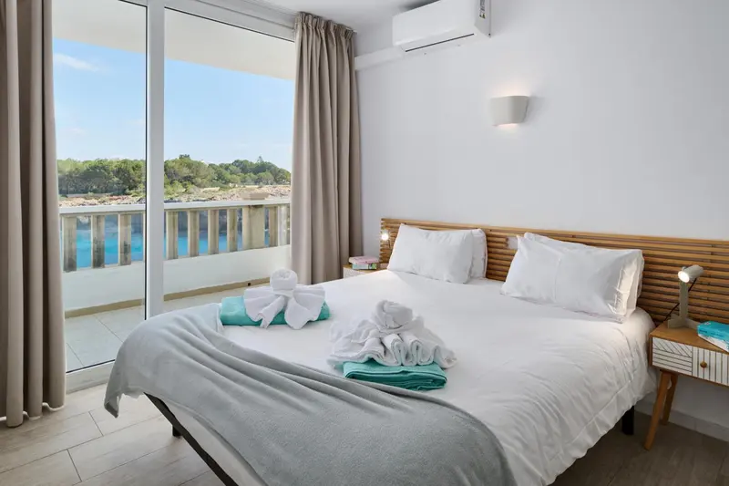 Une chambre lumineuse avec un grand lit et une vue sur la mer.
