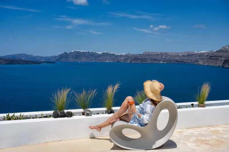 Une personne se relaxe sur une chaise design face à la mer.