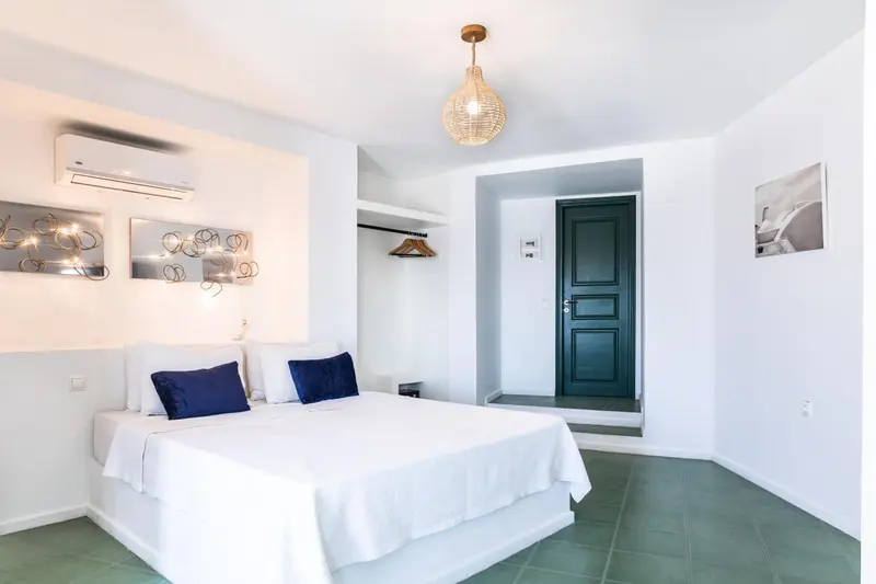 Une chambre lumineuse avec un lit blanc et un décor mural.