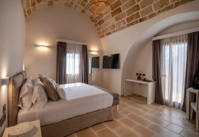 Une chambre lumineuse avec un lit double et un bureau.