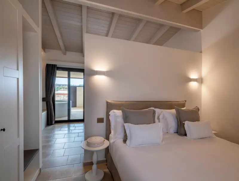 Une chambre lumineuse avec un grand lit et un accès à une terrasse.