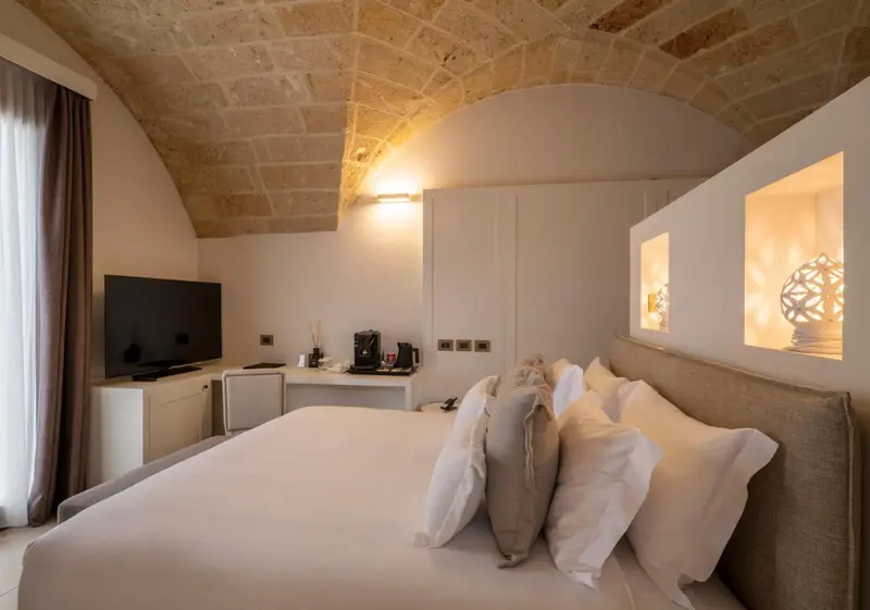 Une chambre lumineuse avec un grand lit et un téléviseur mural.