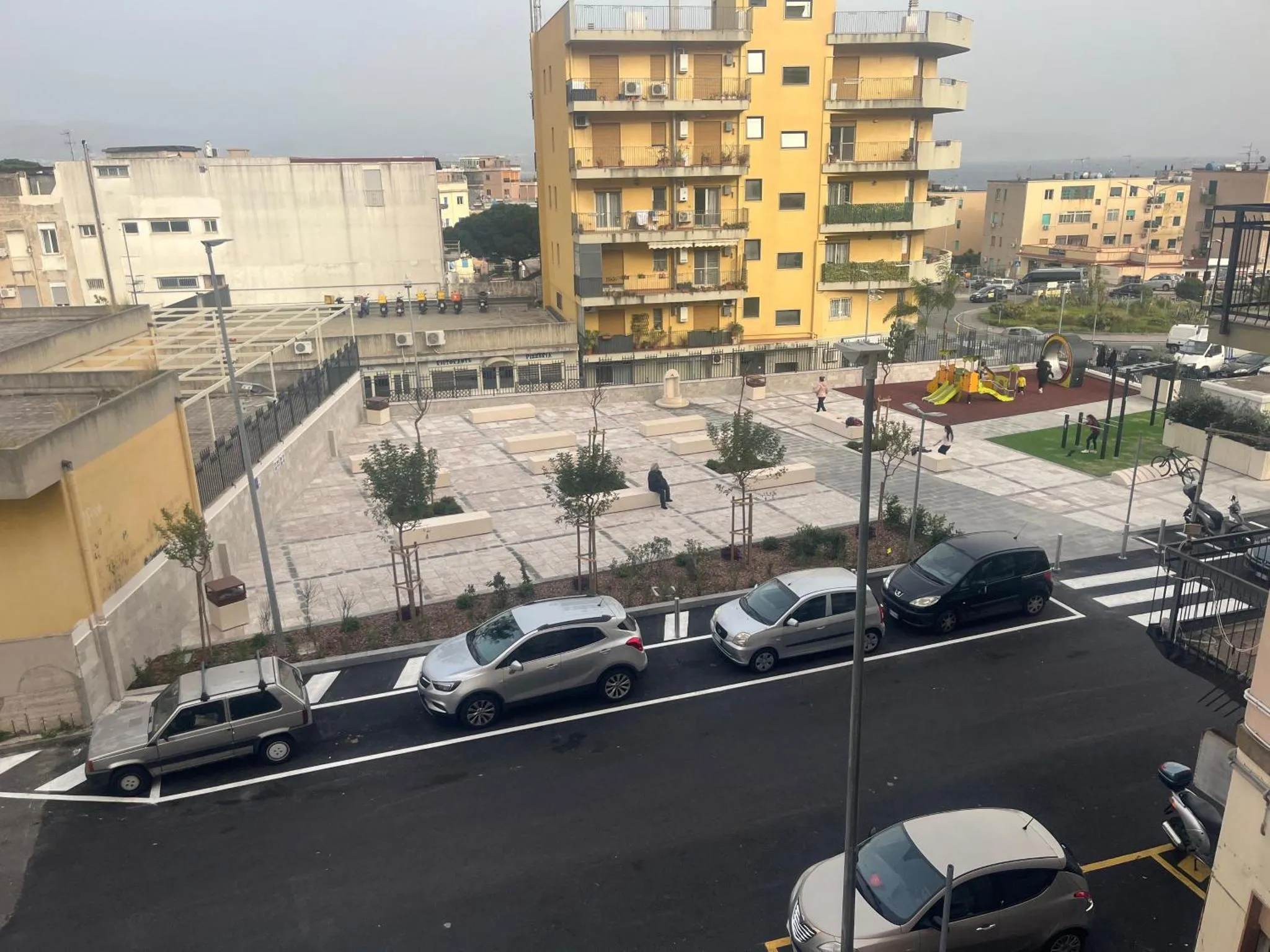Vue d'une cour intérieure avec des bâtiments résidentiels et une aire de jeux pour enfants.
