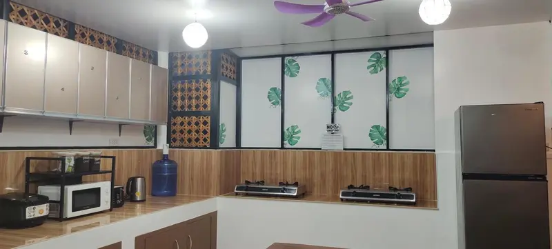 Une cuisine équipée avec des placards, un plan de travail et des plaques de cuisson.