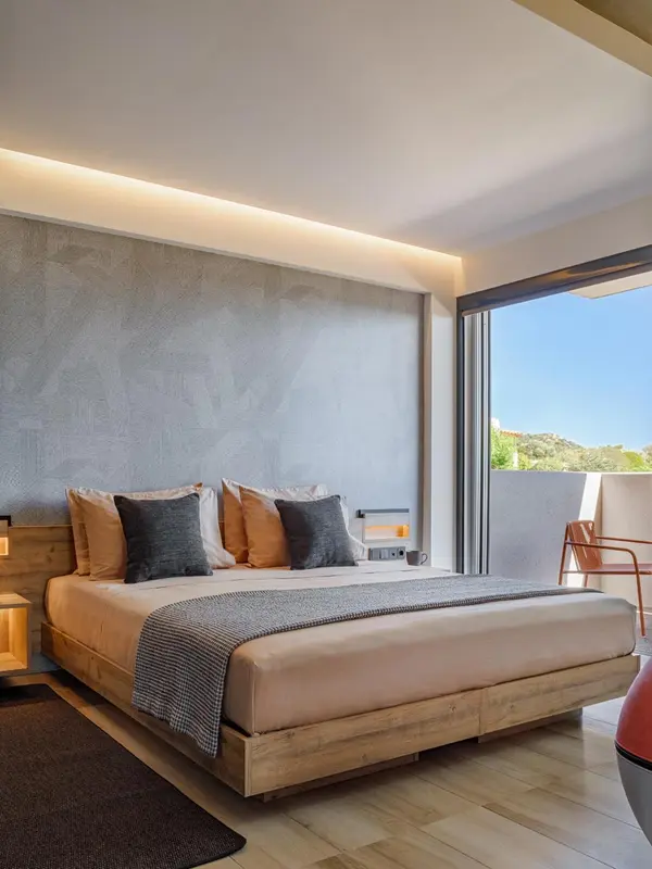 Une chambre lumineuse avec un grand lit et une terrasse.