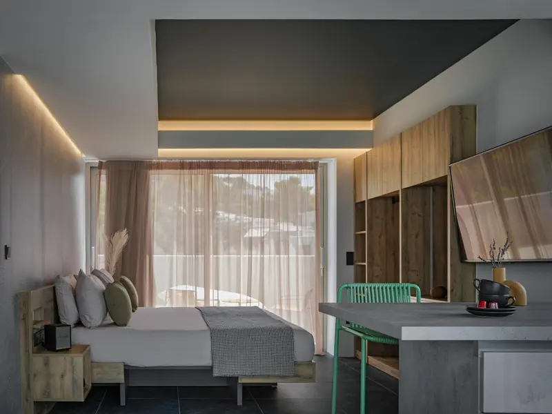 Une chambre lumineuse avec un lit et un coin repas.
