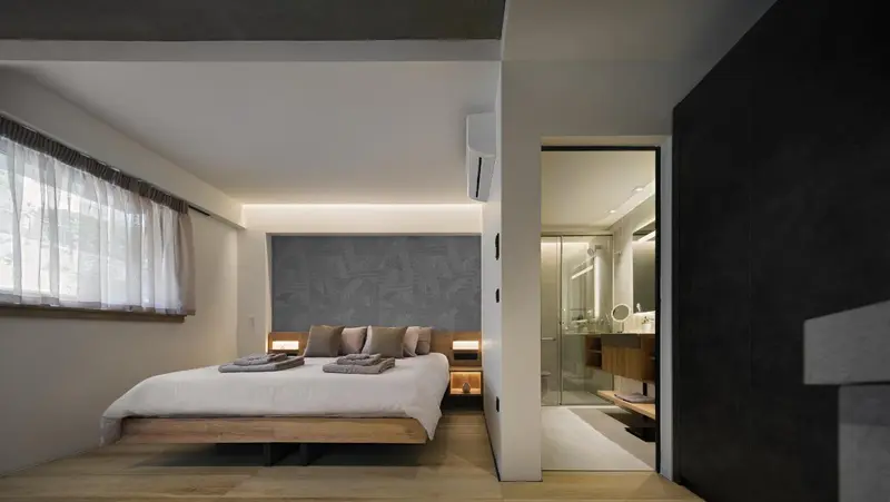 Une chambre lumineuse avec un grand lit et un accès à une salle de bain moderne.