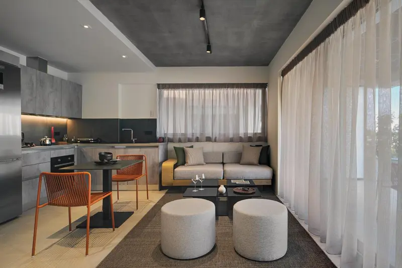 Espace de vie moderne avec coin repas et canapé gris.