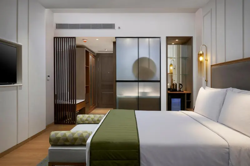 Une chambre lumineuse avec un grand lit et un espace détente.